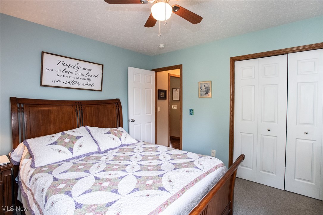 126 Timber Ridge Drive Elyria, OH 44035 - Photo 32 of 49 Bedroom with dark carpet, a closet, ceiling fan, and a textured ceiling