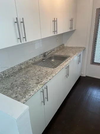 a kitchen with a stove and white cabinets