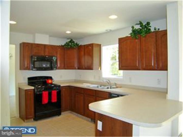 114 Sooy Place Road Tabernacle, NJ 08088 - Photo 5 of 24 a kitchen with granite countertop a stove a sink and a refrigerator