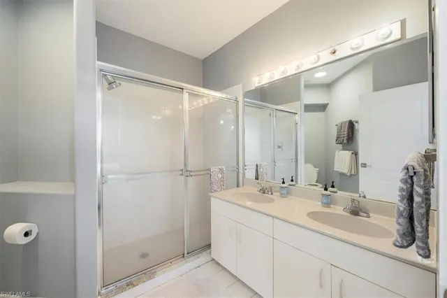 a bathroom with a double vanity sink mirror and shower
