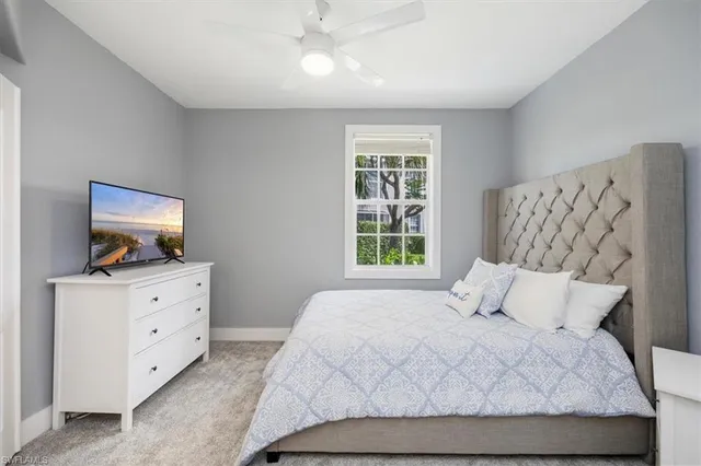 a bedroom with a large bed and flat tv screen on the dresser