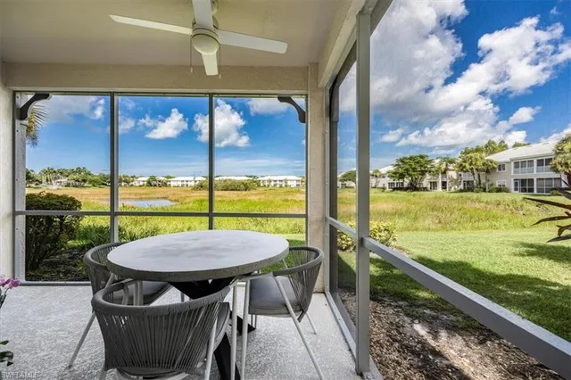 a view of a patio with a table chairs potted plants and wooden floor