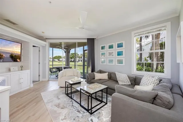 a living room with furniture large window and wooden floor