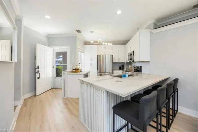 a kitchen with a table chairs refrigerator and cabinets