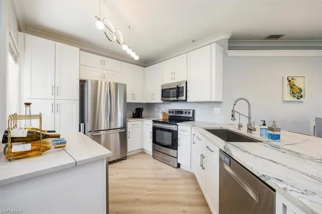 a kitchen with a sink appliances and cabinets