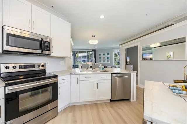 a kitchen with stainless steel appliances a stove microwave and sink
