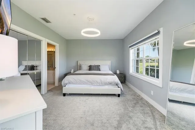 a spacious bedroom with a bed and a large window