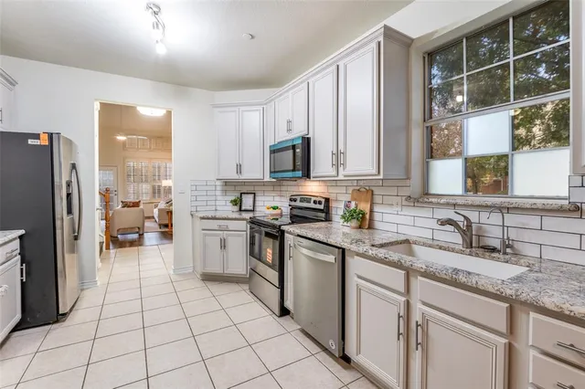 a kitchen with a sink a counter top space stainless steel appliances and cabinets