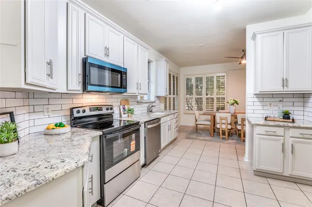 a kitchen with a sink a stove top oven and cabinets
