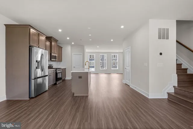 a view of kitchen view wooden floors appliances and cabinets