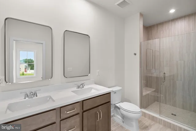 a bathroom with a double vanity sink toilet and shower