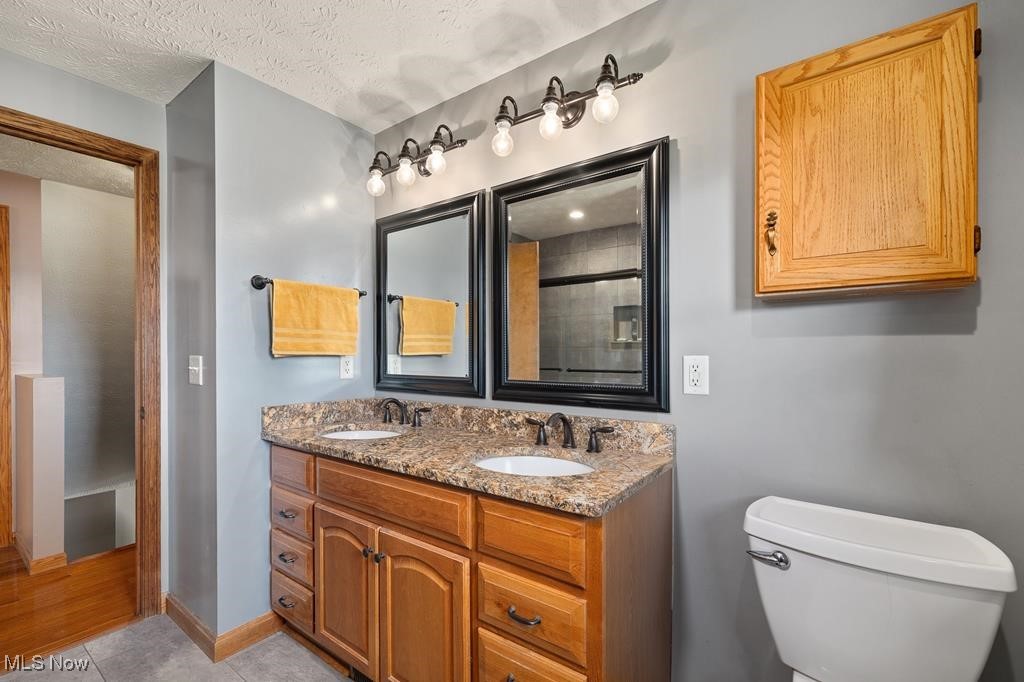 12367 Stratton Road West Salem, OH 44287 - Photo 14 of 26 Bathroom with walk in shower, vanity, a textured ceiling, tile patterned flooring, and toilet