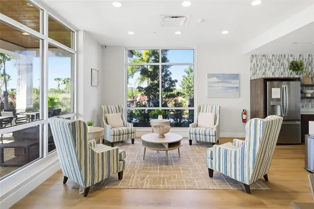 a living room with furniture plant and a large window