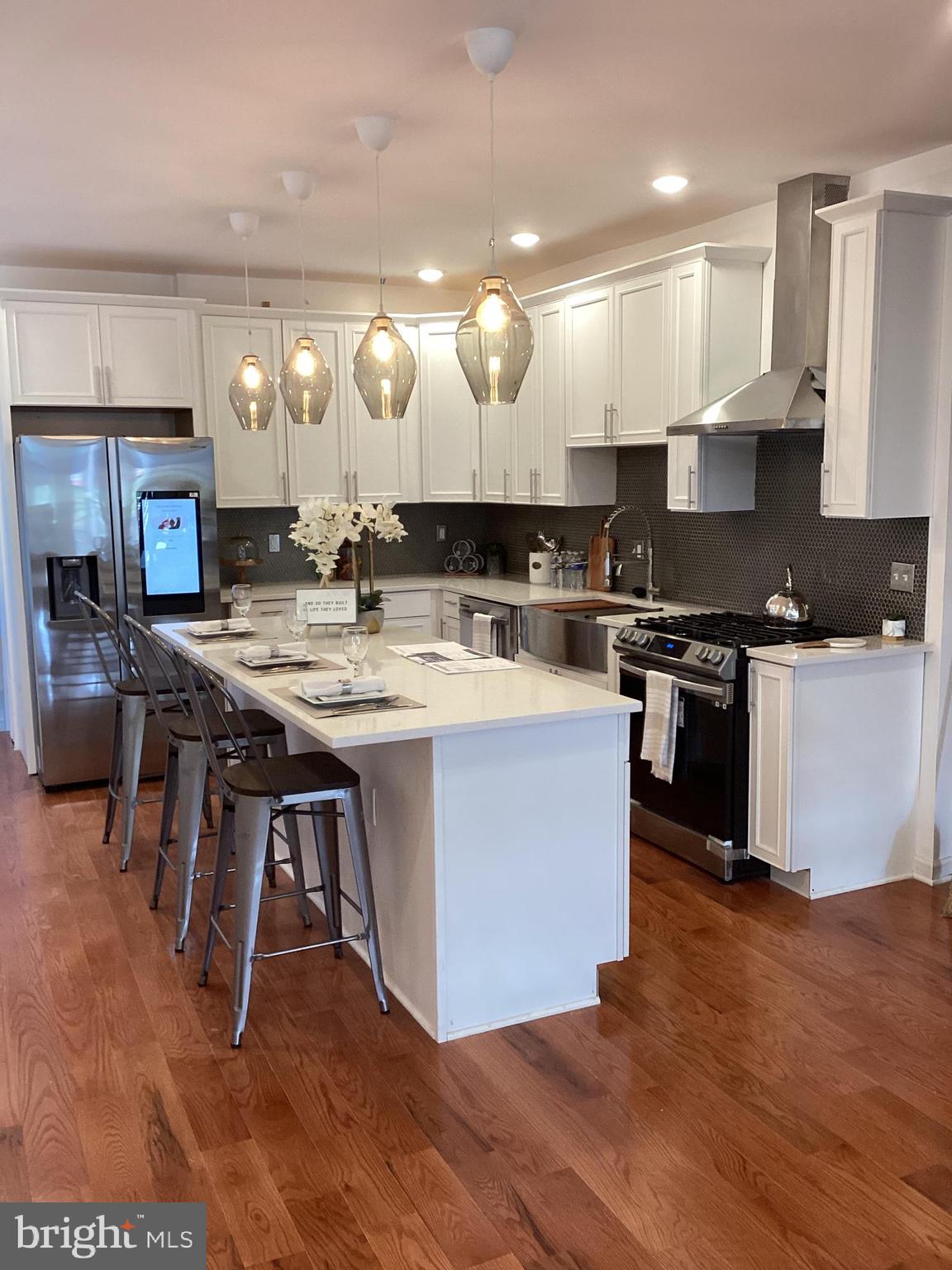 a kitchen with kitchen island a stove a table and chairs in it