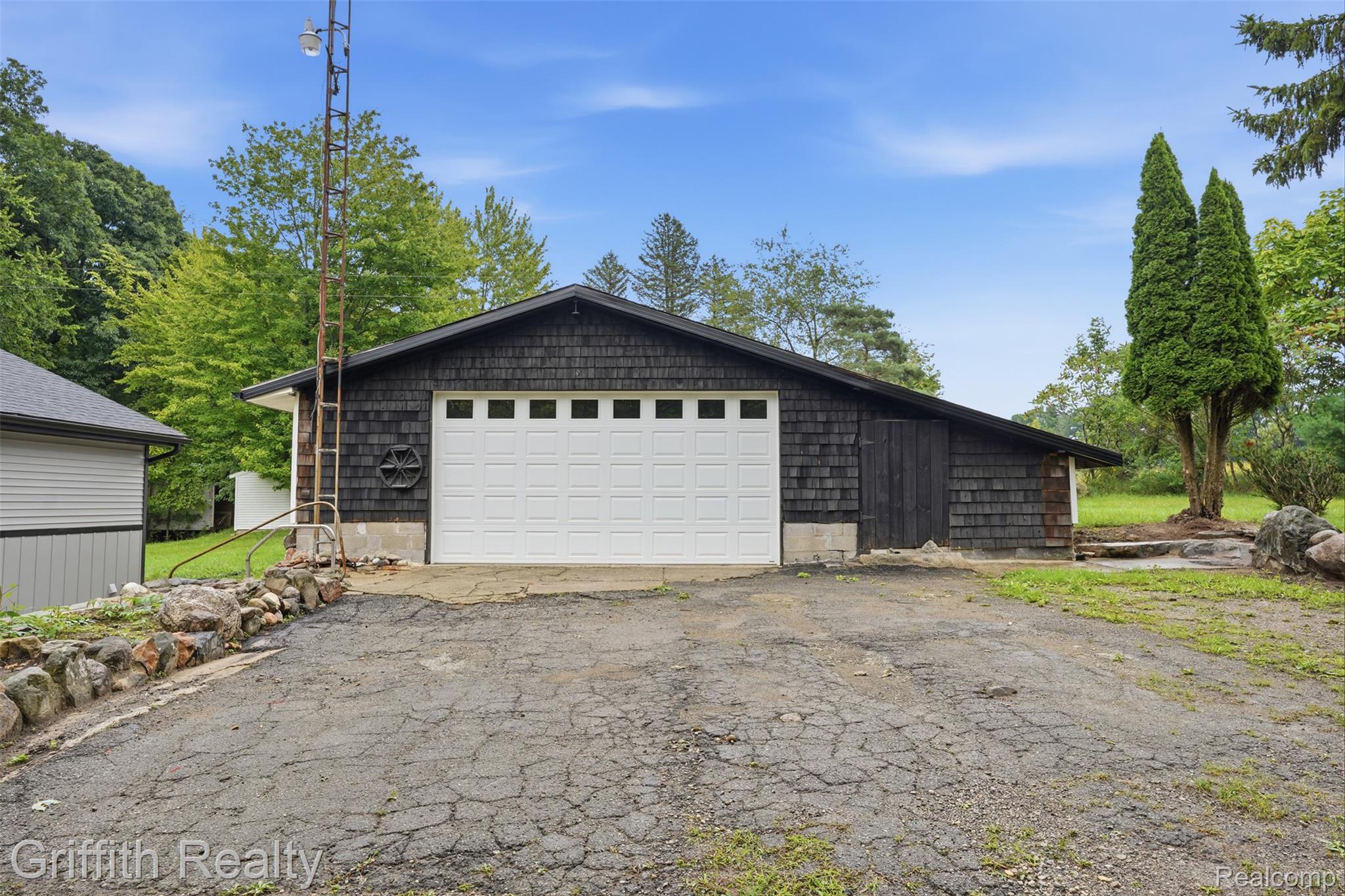 5820 Mack Road Howell, MI 48855 - Photo 3 of 60 Exterior building with dark wood shake siding and a white garage door