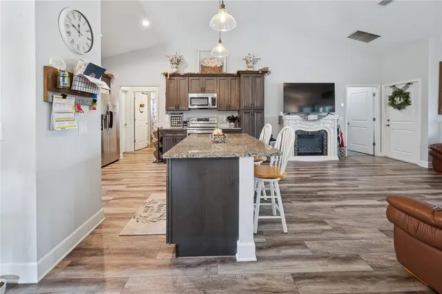 a kitchen with stainless steel appliances kitchen island granite countertop a stove a sink and a microwave