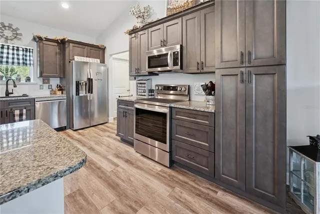 a kitchen with stainless steel appliances granite countertop a refrigerator microwave and sink