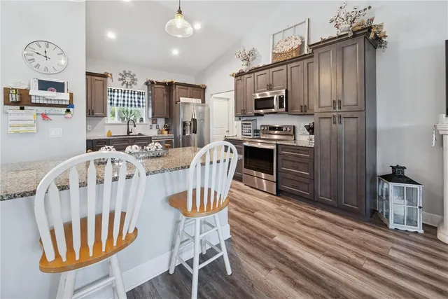 a view of a dining room with furniture a chandelier and wooden floor