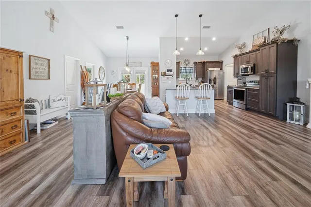 a living room with furniture a wooden floor and a kitchen view