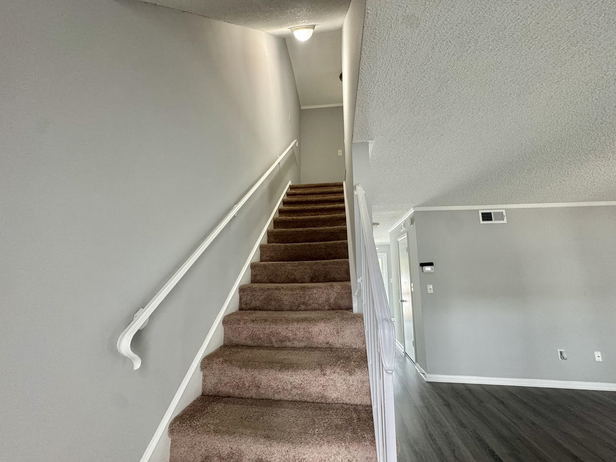 4115 Little River Road, Unit 10B Myrtle Beach, SC 29577 - Photo 19 of 31 Staircase featuring a textured ceiling and wood finished floors
