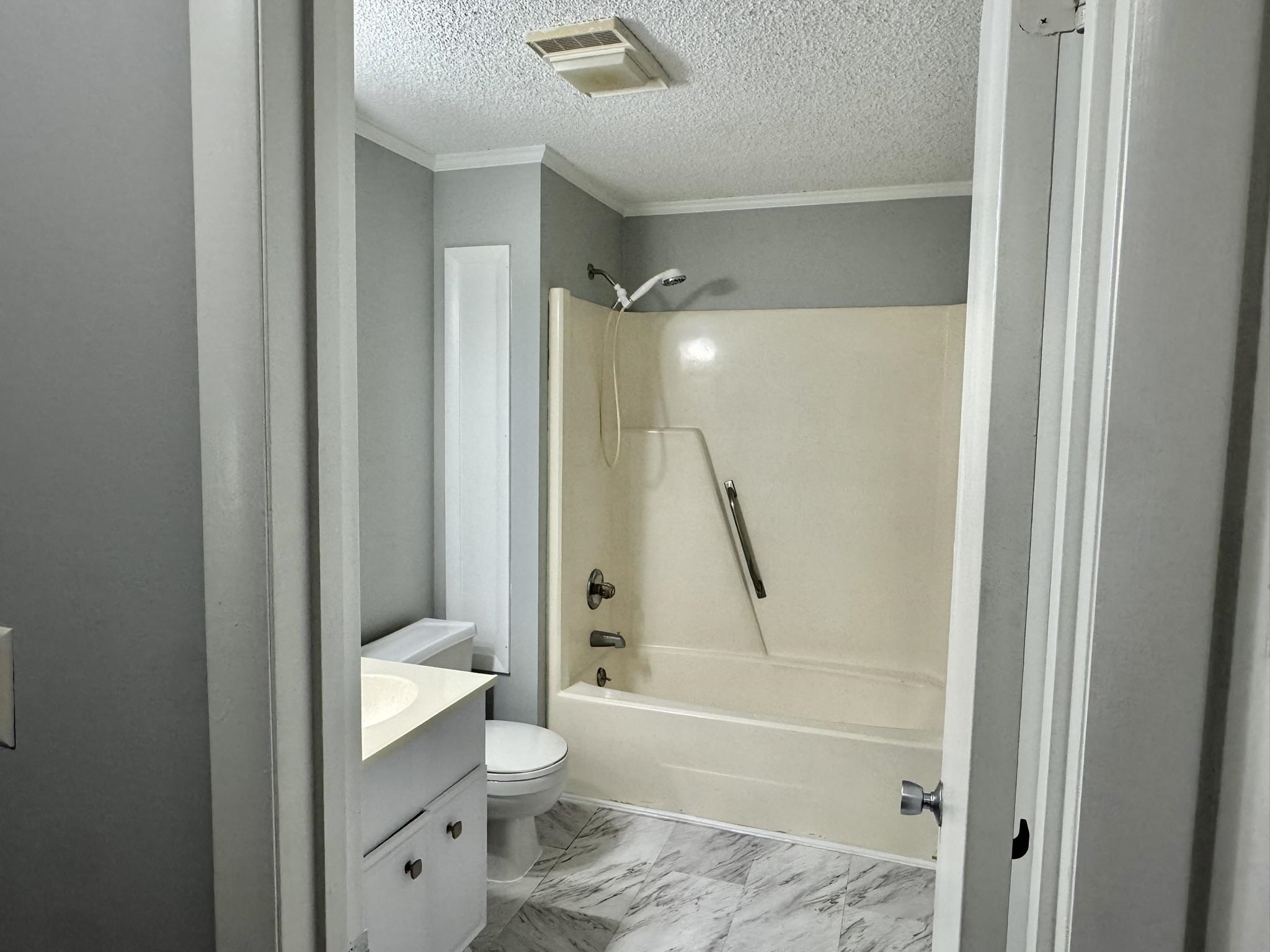 4115 Little River Road, Unit 10B Myrtle Beach, SC 29577 - Photo 24 of 31 Bathroom featuring shower combination, vanity, a textured ceiling, crown molding, and light marble finish floors