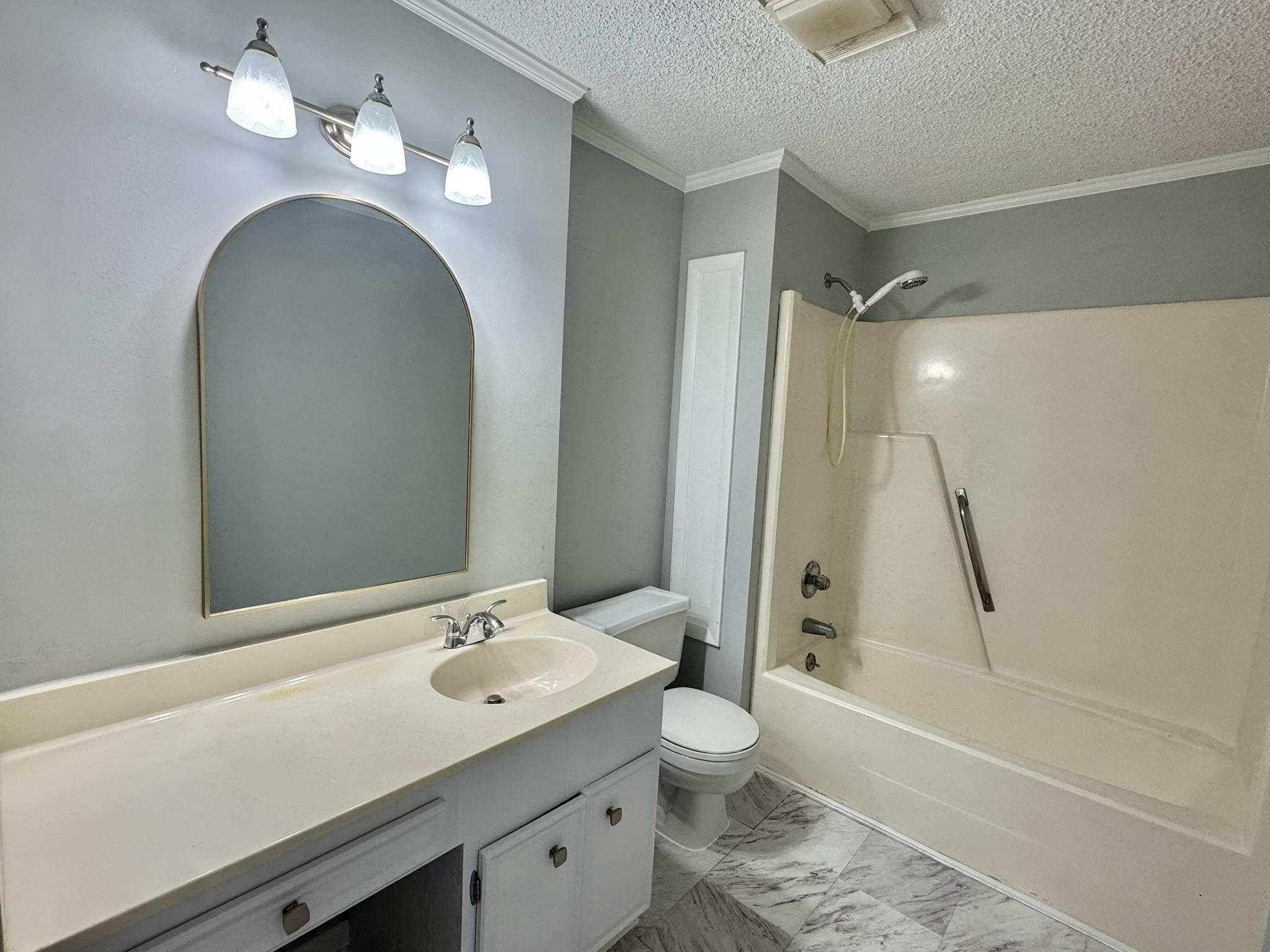 4115 Little River Road, Unit 10B Myrtle Beach, SC 29577 - Photo 26 of 31 Bathroom featuring bathtub / shower combination, vanity, crown molding, a textured ceiling, and light marble finish floors