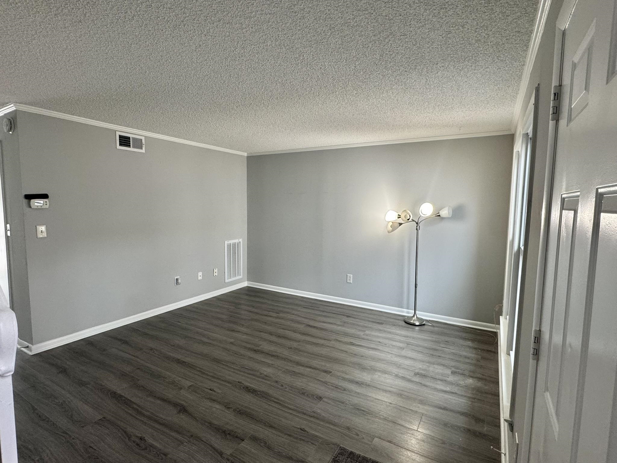 4115 Little River Road, Unit 10B Myrtle Beach, SC 29577 - Photo 3 of 31 Spare room featuring dark wood-type flooring, ornamental molding, and a textured ceiling