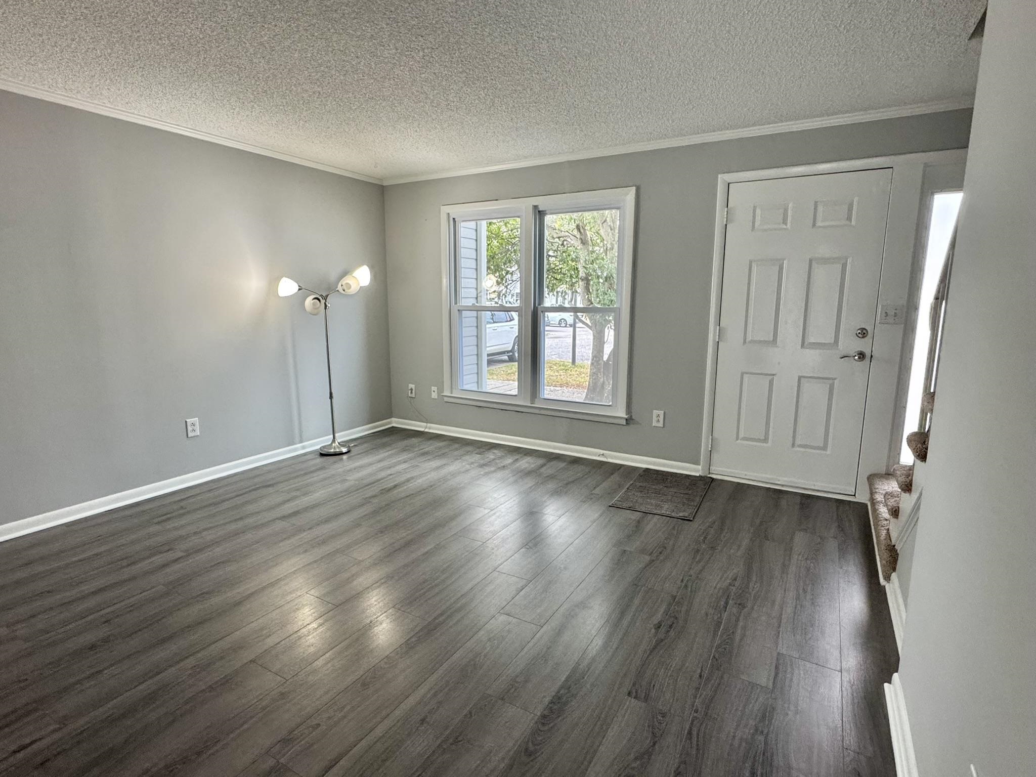 4115 Little River Road, Unit 10B Myrtle Beach, SC 29577 - Photo 4 of 31 Unfurnished room with ornamental molding, a textured ceiling, and dark wood-style flooring
