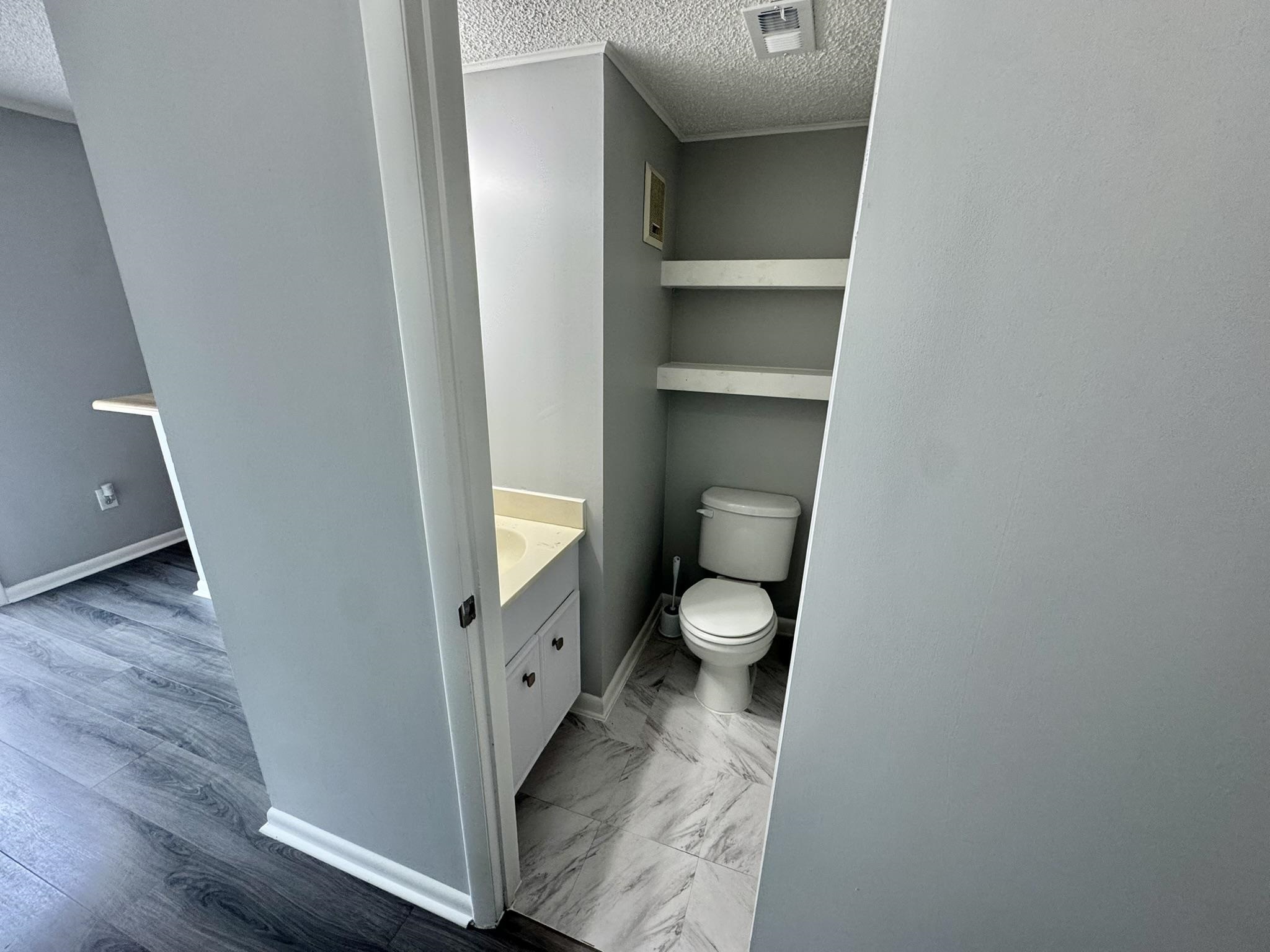 4115 Little River Road, Unit 10B Myrtle Beach, SC 29577 - Photo 7 of 31 Half bath featuring a textured ceiling, vanity, and light marble finish floors