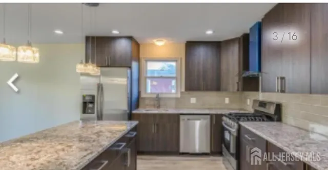 a kitchen with stainless steel appliances granite countertop a sink a stove and a refrigerator