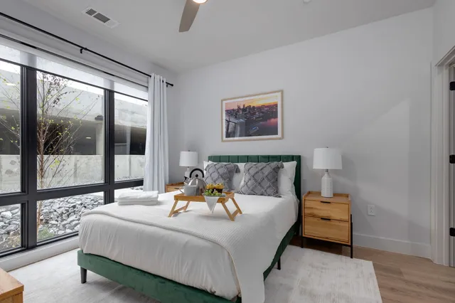 a bedroom with a bed and large window