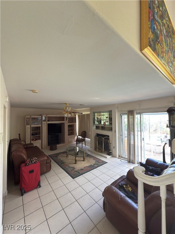 815 Rising Star Drive Henderson, NV 89014 - Photo 11 of 12 Living area with a fireplace with raised hearth, light tile patterned flooring, and a ceiling fan