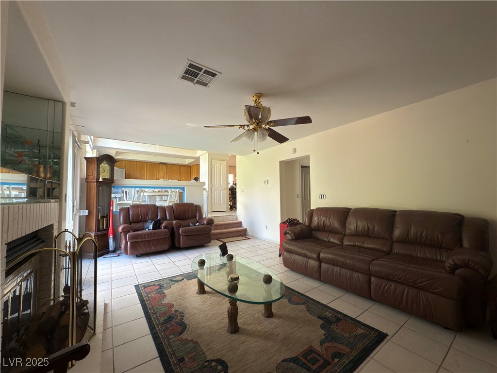 815 Rising Star Drive Henderson, NV 89014 - Photo 12 of 12 Living room featuring a brick fireplace, a ceiling fan, and light tile patterned floors