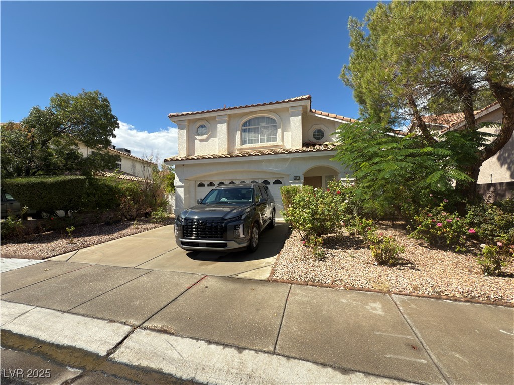 815 Rising Star Drive Henderson, NV 89014 - Photo 2 of 12 Mediterranean / spanish-style home with concrete driveway, stucco siding, a tile roof, and a garage