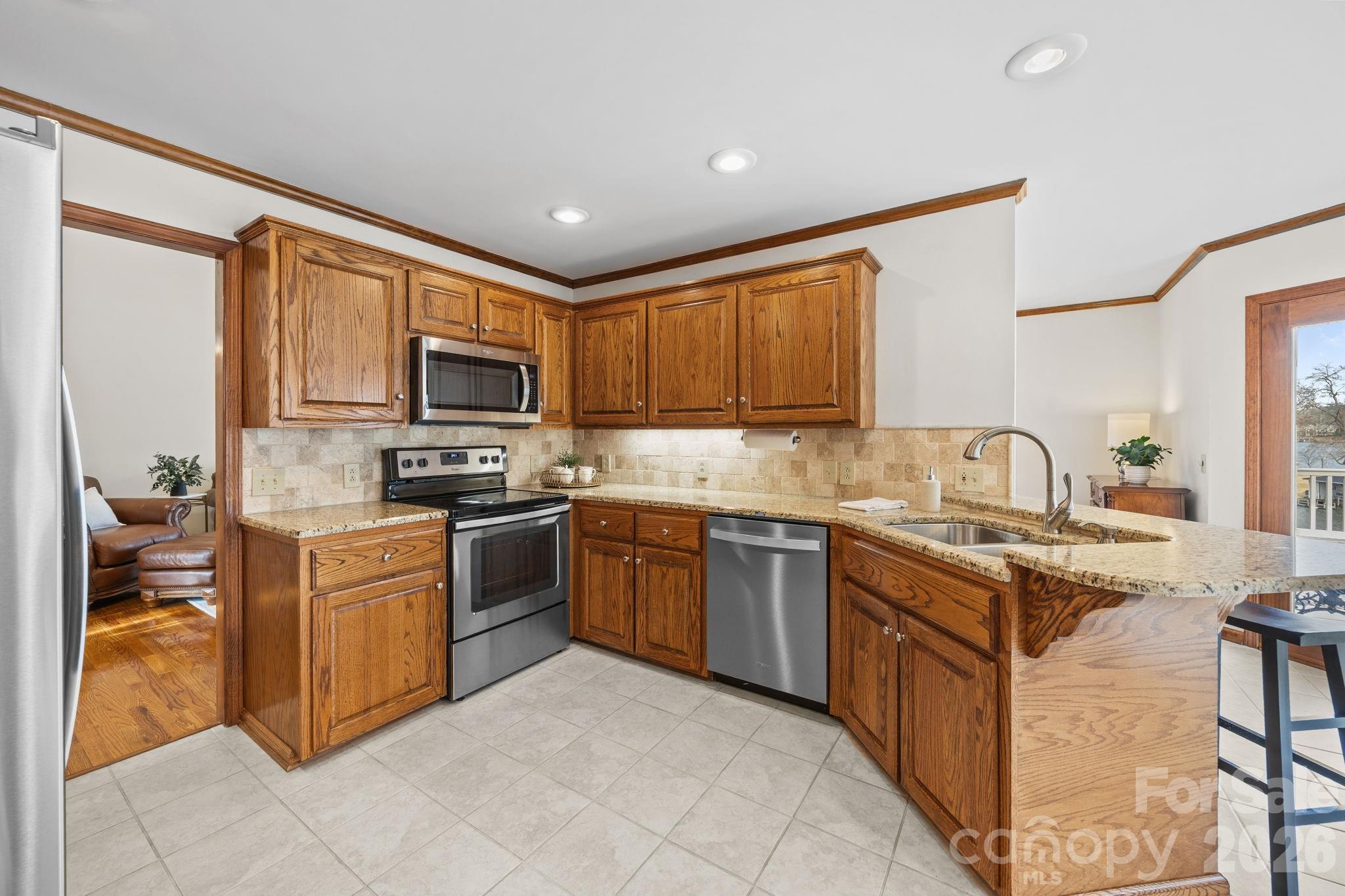 49449 River Run Road Albemarle, NC 28001 - Photo 11 of 45 a kitchen with stainless steel appliances granite countertop a stove top oven a sink dishwasher a refrigerator and a microwave oven