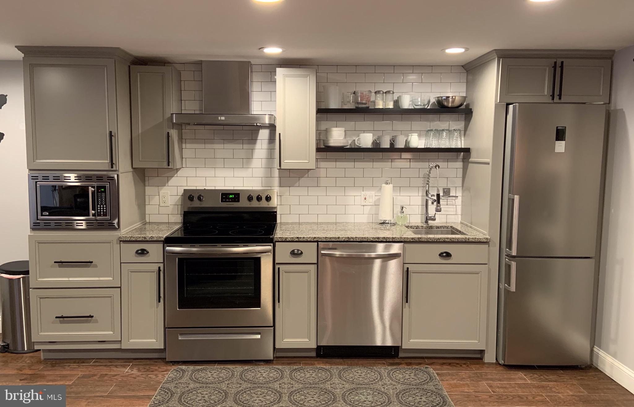 10 N Street Northwest, Unit STREET Washington, DC 20001 - Photo 2 of 11 a kitchen with stainless steel appliances granite countertop a stove a refrigerator and a stove top oven