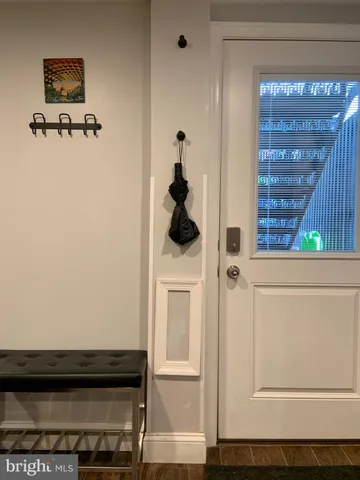 a view of hallway with wooden floor and cabinet