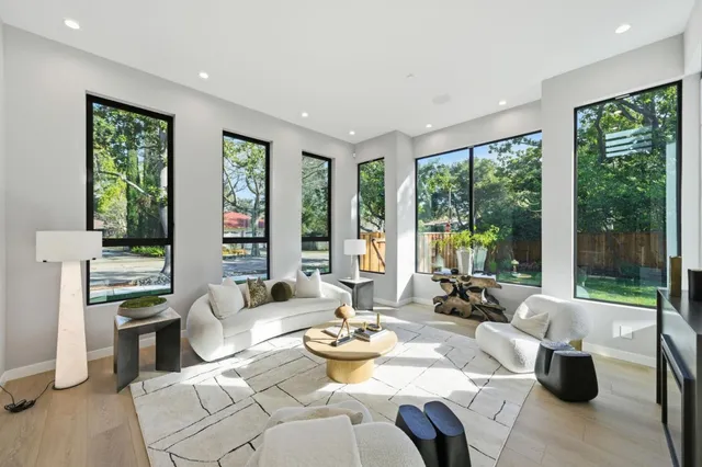 a view of a dining room with furniture large windows and garden view
