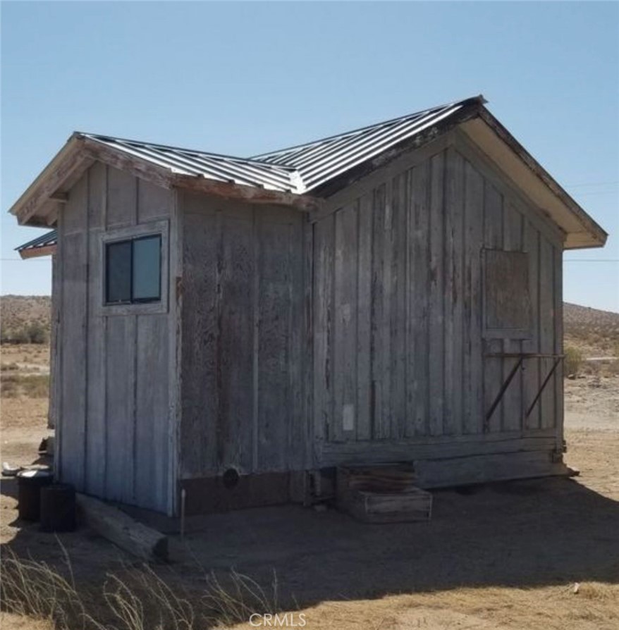 5151 Highway 395 Ridgecrest, CA 93555 - Photo 13 of 13 a black house with wooden fence in front of it