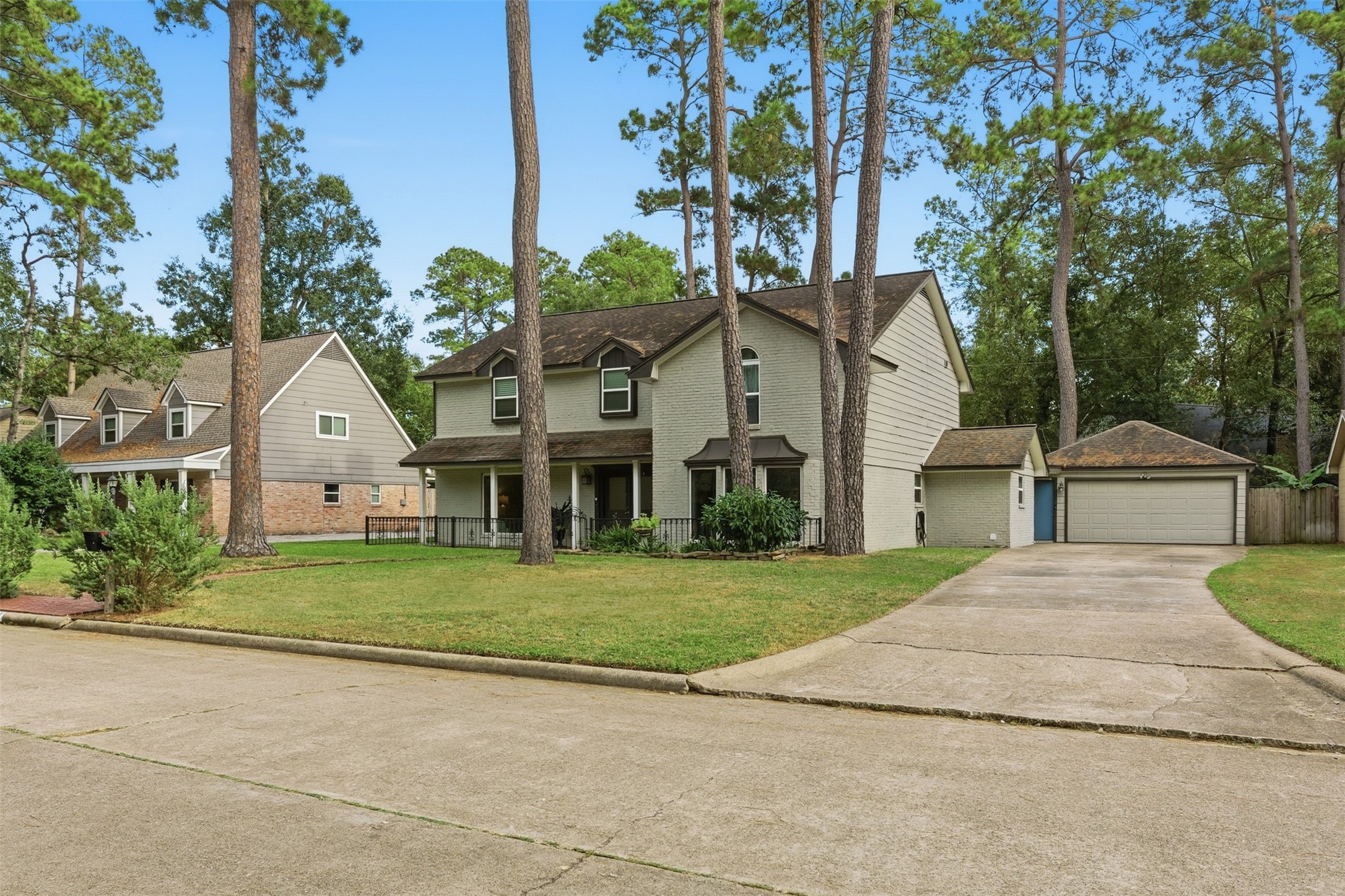 a front view of a house with a yard and trees