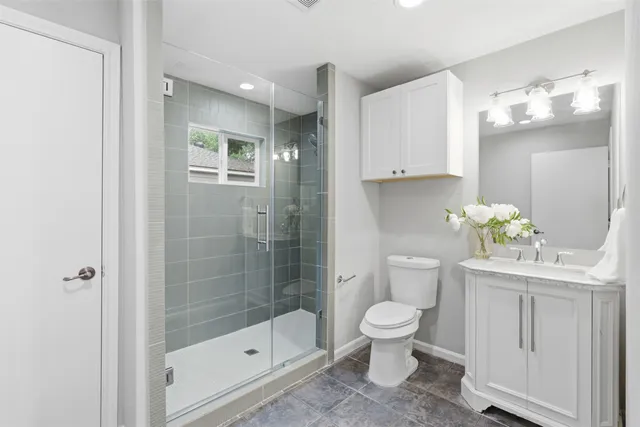 a bathroom with a shower a toilet and a sink