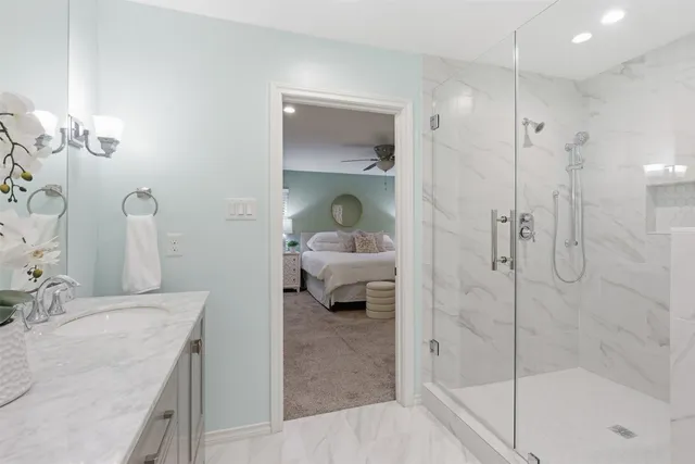 a en suite bathroom with a granite countertop sink and a shower