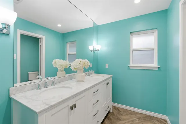 a bathroom with a granite countertop sink and a mirror