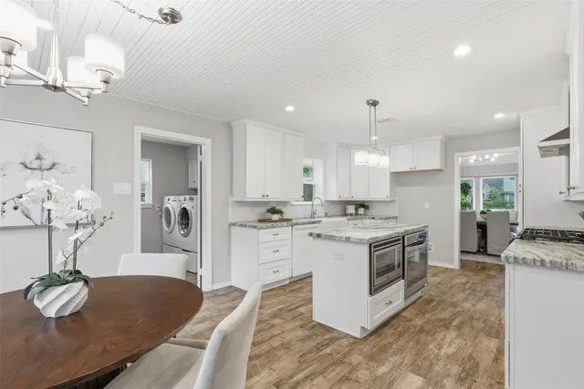 a kitchen with stainless steel appliances granite countertop a stove oven and a refrigerator with white cabinets