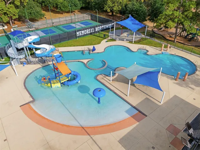 an aerial view of a swimming pool with outdoor seating