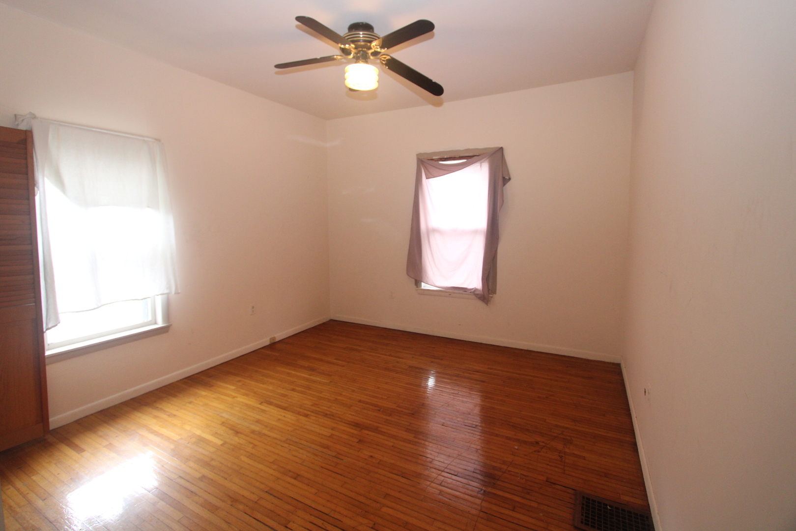 620 Oneida Street Joliet, IL 60435 - Photo 18 of 28 an empty room with wooden floor fan and windows