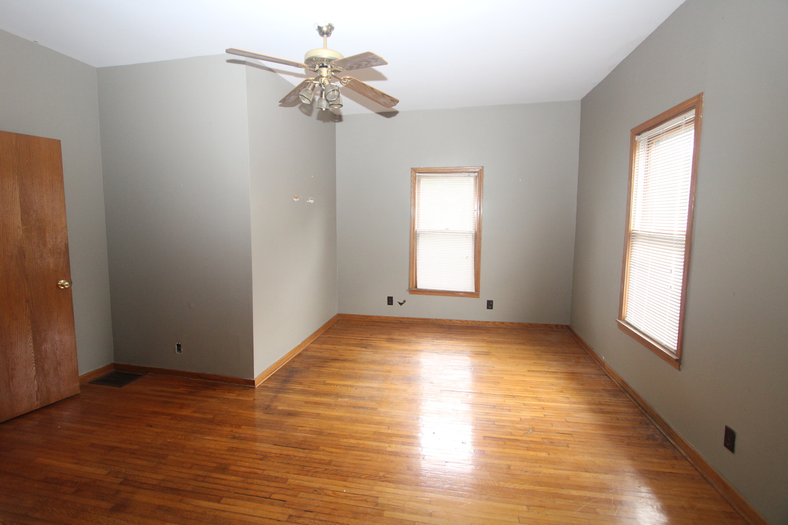 620 Oneida Street Joliet, IL 60435 - Photo 21 of 28 an empty room with wooden floor chandelier and windows