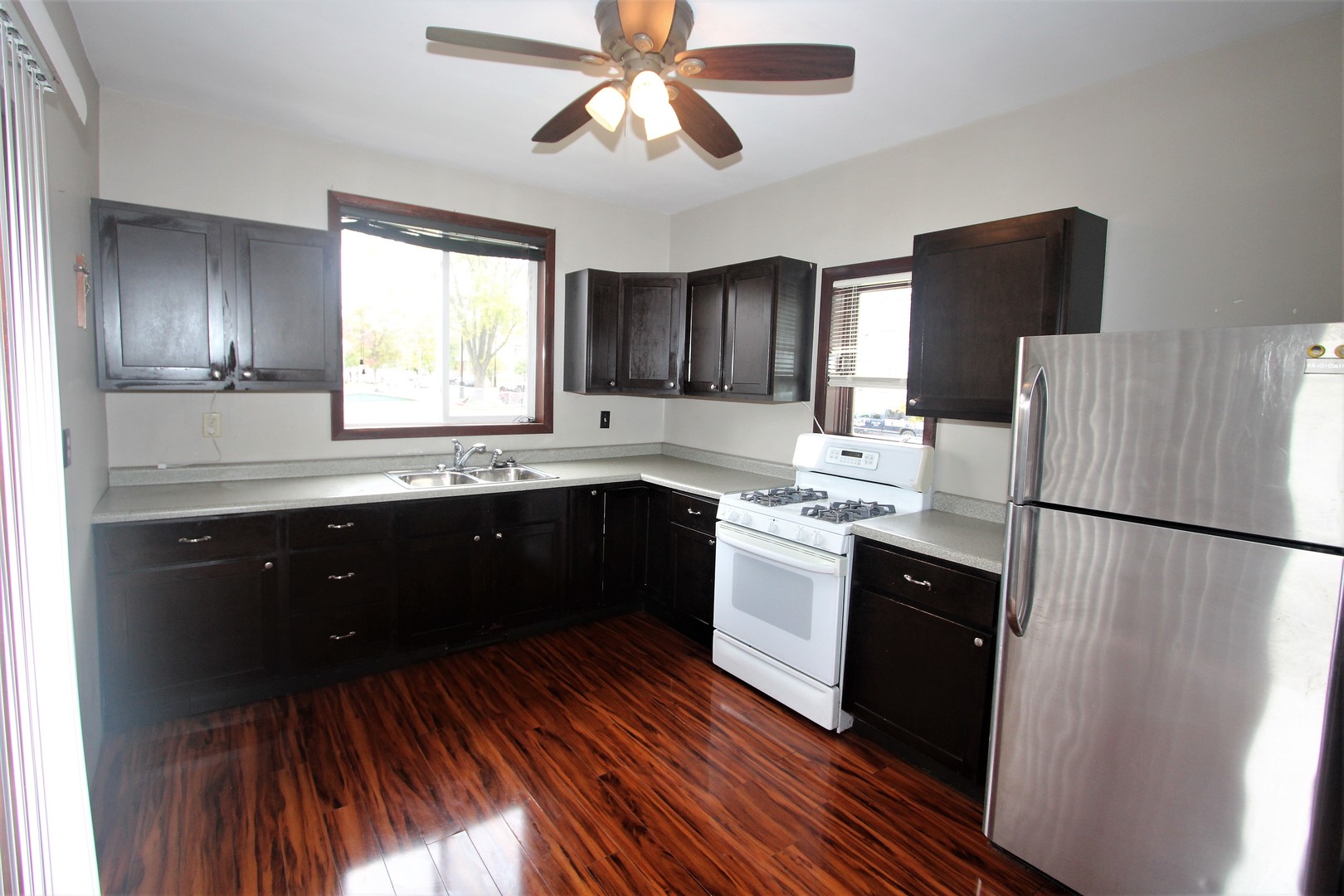 620 Oneida Street Joliet, IL 60435 - Photo 7 of 28 a kitchen with a refrigerator a sink and dishwasher with wooden floor