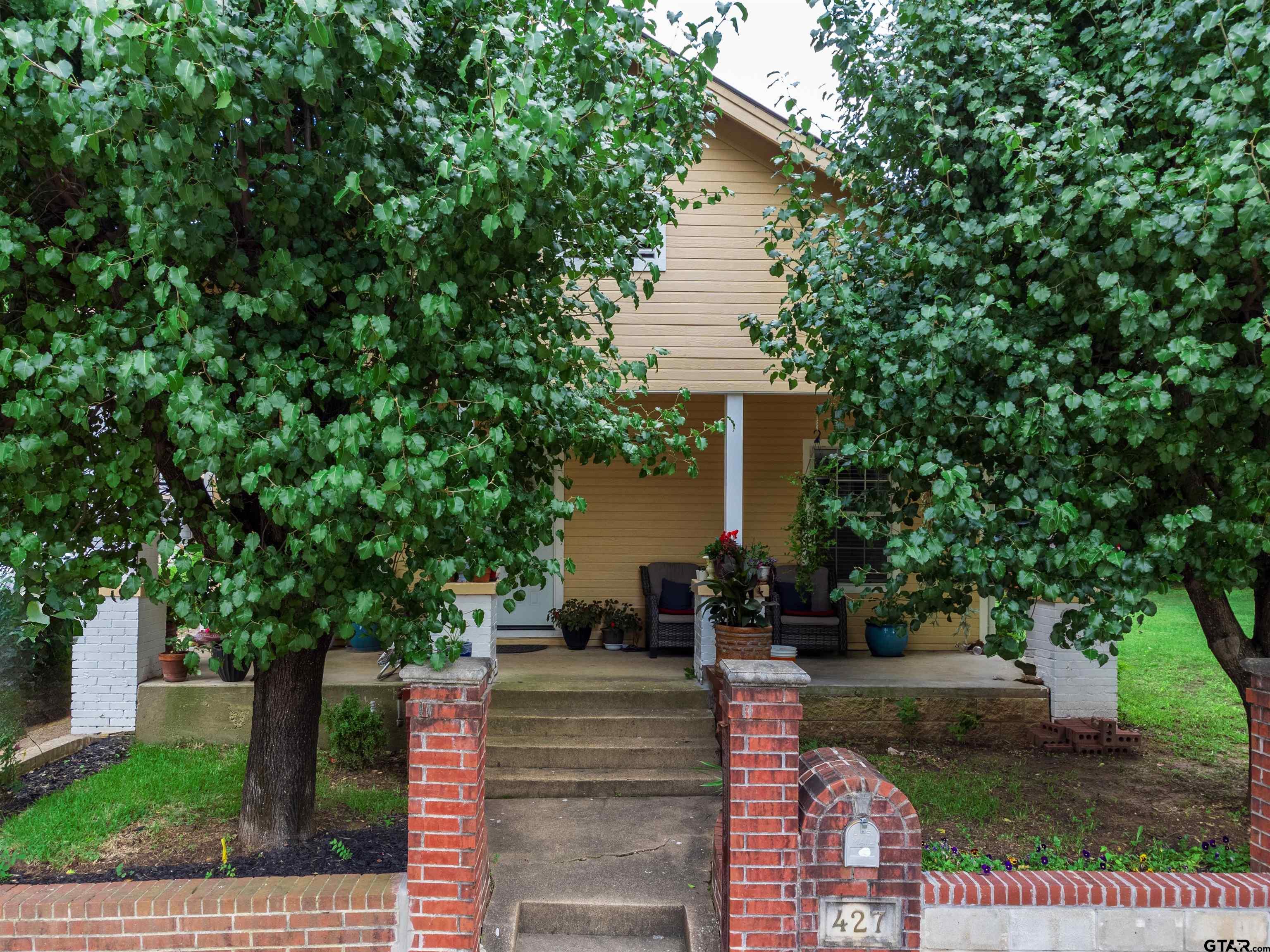 427 East Locust Street Tyler, TX 75702 - Photo 1 of 42 a view of a house with fountain and large trees