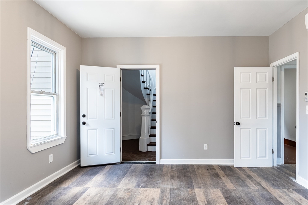 50 Tecumseh Street Fall River, MA 02721 - Photo 8 of 36 a view of an empty room with window and wooden floor